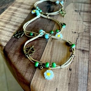 Three adjustable, string bracelets